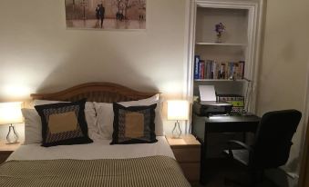 a cozy bedroom with a bed , desk , and bookshelf , along with some decorative items on the wall at Union Apartments