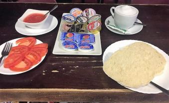 a table with a plate of tortilla and other food items , including soup and ketchup , next to a cup of coffee at La Esperanza