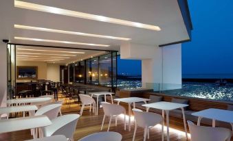 a modern restaurant with white chairs and tables , overlooking a city skyline at night at Rocksalt