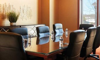 a conference room with a long wooden table surrounded by black chairs and two glass bottles on each table at Mount Airy Casino Resort - Adults Only 21 Plus