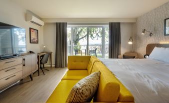 a modern living room with a yellow couch , a dining table , and a balcony overlooking the ocean at Hotel Verso