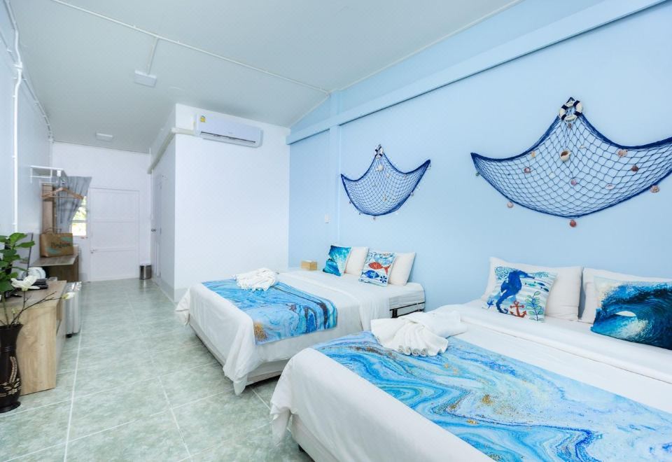 a hotel room with two beds , one on the left and one on the right side of the room at Pimtara Beach Resort