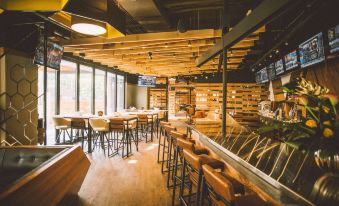 a modern restaurant with wooden tables and chairs , a bar , and a large window overlooking the city at Delta Hotels by Marriott Waterloo