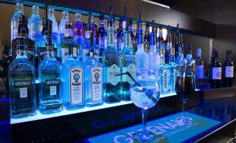 a well - stocked bar with numerous bottles of alcohol , including several types of gin , vodka , and whiskey at Holiday Inn Express London - Dartford