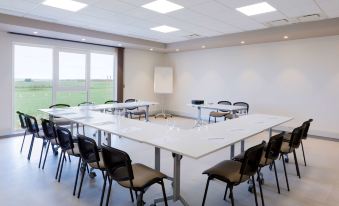 a conference room with a long table , chairs , and a whiteboard set up for a meeting at Best Western Hotel le Semaphore