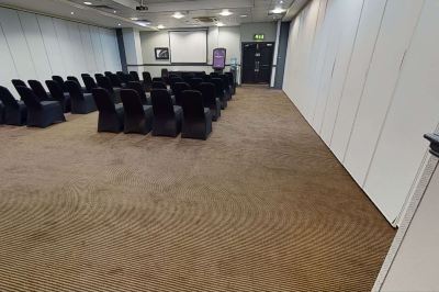 a large conference room with multiple rows of chairs arranged in a semicircle , and a podium at the front of the room at Village Hotel Liverpool