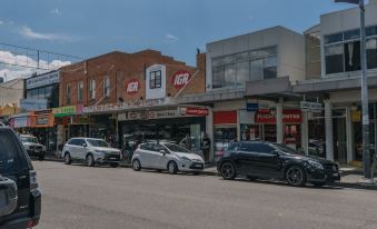 a street view of a row of cars parked in front of various businesses , including the hsbc bank and kfc at Hamilton on Beaumont