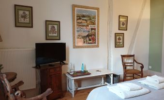 a bedroom with a bed , wooden furniture , and framed pictures on the wall , featuring a television and a chair at Ombre Rose