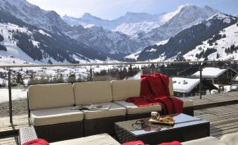 a cozy living room with a couch , coffee table , and snowy mountains in the background at The Cambrian