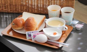 a wooden tray with a loaf of bread , a bowl of soup , and a cup of coffee on a table at Toyota Village