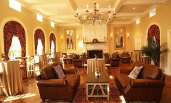 a large room with multiple couches , chairs , and tables arranged in a comfortable seating area at Peter Allen Inn & Event Center