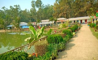 A garden with flowers and plants next to a man-made pond at Hotel Banalata