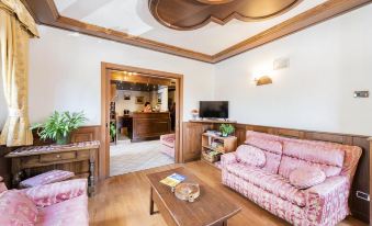 a cozy living room with wooden furniture , including a couch , chairs , and a coffee table at Santa San