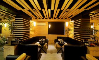 a modern restaurant with wooden ceiling beams and black leather couches , creating an elegant atmosphere at Imperial Heights