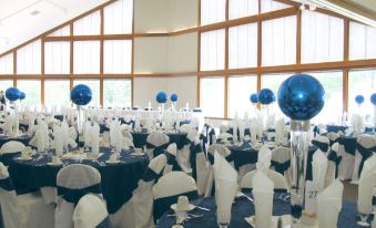 a large room filled with tables and chairs , each table is adorned with blue and white tablecloths , balloons , and other decorations at Devil's Head Resort