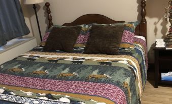 a bed with a wooden headboard and colorful bedding is shown in a bedroom with two lamps on either side at Red Rock Inn