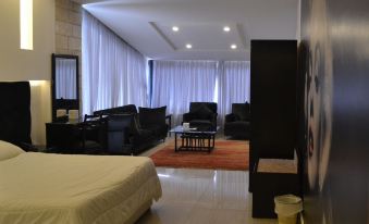 a modern hotel room with a bed , couch , and dining table , all arranged in a spacious layout at Platinum Hotel