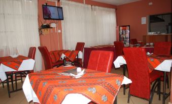 a restaurant with red chairs and tables , a television mounted on the wall , and a television on the wall at The Ree