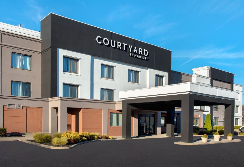 the exterior of a courtyard by marriott hotel , with its black and white facade and red brick flooring at Courtyard Newburgh Stewart Airport