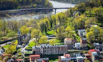 an aerial view of a small town with a bridge spanning a river , surrounded by greenery and trees at Town's Inn
