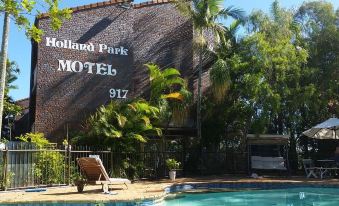 "a brick building with a pool and a sign that reads "" the island park hotel "" on it" at Holland Park Motel