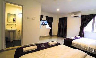 a clean and well - organized hotel room with two beds , a tv , and a bathroom nearby at Hotel Lavender Senawang