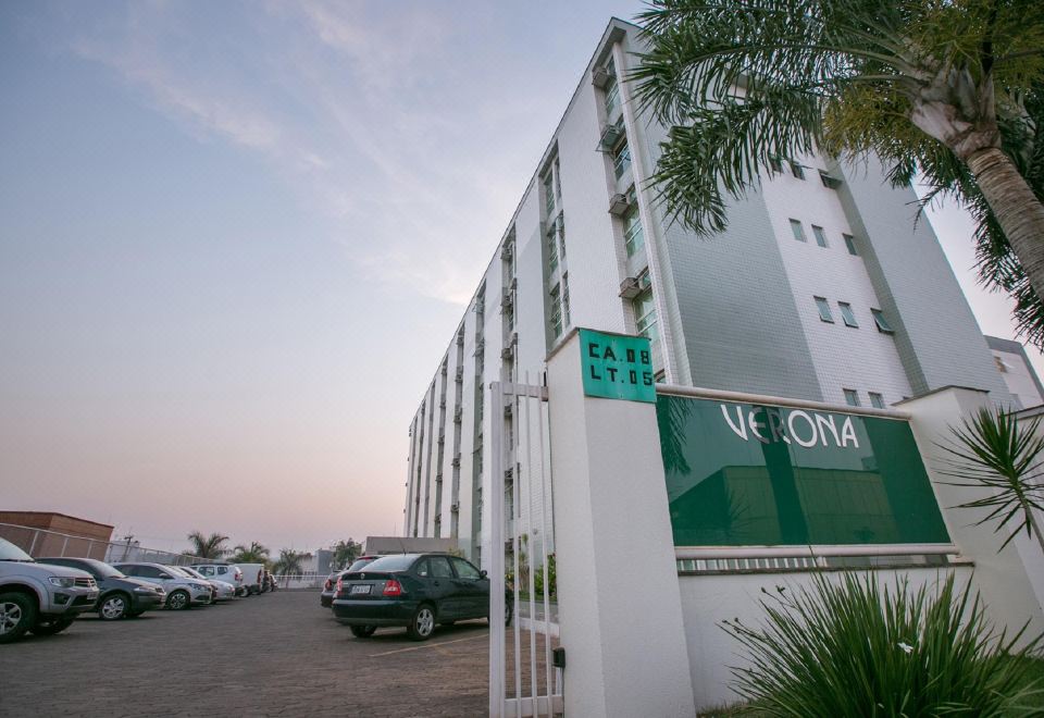 "a large white building with the word "" victoria "" on it , surrounded by a parking lot and palm trees" at Verona Hplus Long Stay