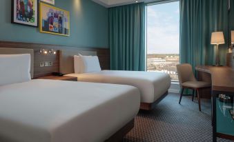 a hotel room with two beds , one on the left and one on the right side of the room at Hampton by Hilton  Edinburgh Airport