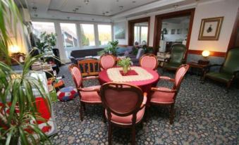 a large dining table with pink chairs and a heart - shaped center piece is surrounded by wooden chairs in a room at Waterfront