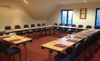 a large conference room with multiple tables and chairs arranged for a meeting or event at Bayview Hotel