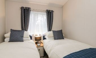 a small bedroom with two twin beds , one on the left and one on the right side of the room at Woodstock Lodge