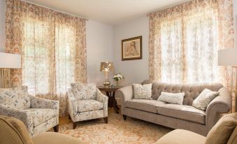 a cozy living room with a large beige couch , two chairs , and a potted plant at Gothic Eves Inn and Spa Bed and Breakfast