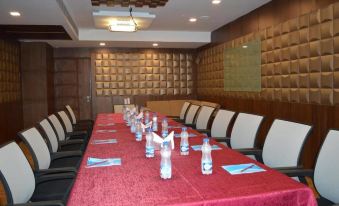 a conference room set up for a meeting , with several chairs arranged around a long table and water bottles on the table at Budget Hotel