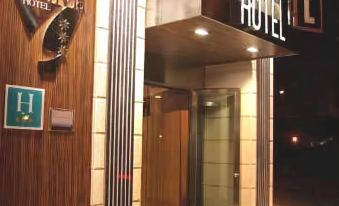 a hotel entrance with a wooden door and a sign above it , indicating that it is a motel at Hotel Gran Via