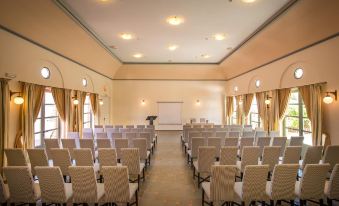 a large conference room with rows of chairs arranged in a semicircle , ready for a meeting or event at Bella Beach Hotel
