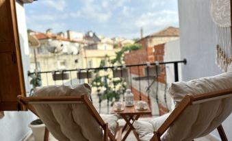 The apartment's rooftop terrace offers a balcony with chairs and a table, providing a scenic view of the city at Hanole Guest House