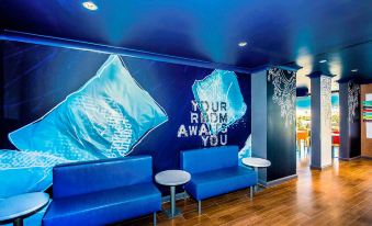 a room with blue walls and a large blue wall mural , along with two blue couches at Ibis Budget Brisbane Airport