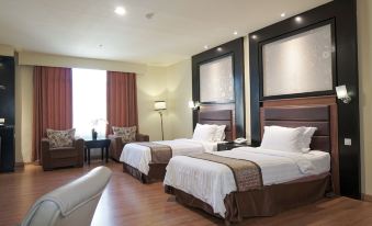 a hotel room with two beds , one on the left and one on the right side of the room at Sari Ater Kamboti Hotel Bandung