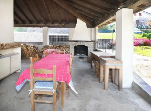 Large apartment with covered outdoor patio with table and barbecue.