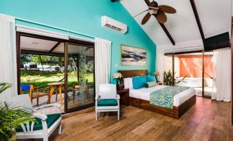 a bedroom with a large bed , wooden floors , and sliding glass doors leading to an outdoor patio at Bahia del Sol Beach Front Boutique Hotel