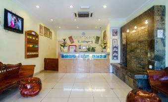 a hotel lobby with a reception desk , two red spherical sculptures , and a brick wall at Sun Inns Hotel Kuala Selangor