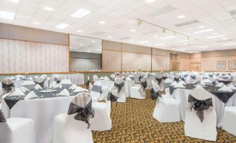 a large banquet hall with multiple tables and chairs set up for a formal event at Ramada by Wyndham Cumberland Downtown