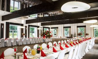 a large , well - lit room with multiple dining tables set for a formal event , including wine glasses , plates , and cutlery at Hotel Diament Zabrze - Gliwice