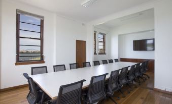 a large conference room with a long white table and multiple chairs arranged around it at Cockatoo Island Accommodation