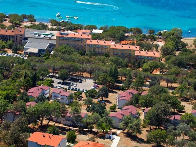 aerial view of a small town near the ocean , with multiple buildings and trees surrounding it at Park Plaza Belvedere Medulin