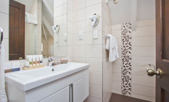 a modern bathroom with white tiles , a bathtub , and a shower area equipped with towels at Knights Inn