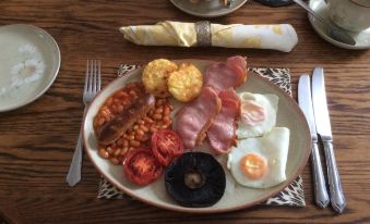 a plate of food on a dining table , consisting of various meats , eggs , and vegetables at Laurel Lodge