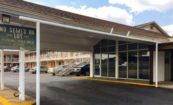 a car parked in front of a motel with a carport and a car parked on the street at Thunderbird Motel Hillsboro