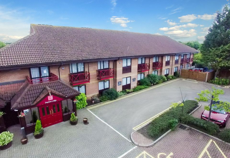 an aerial view of a hotel with red doors and windows , surrounded by trees and plants at Peartree Lodge Waterside
