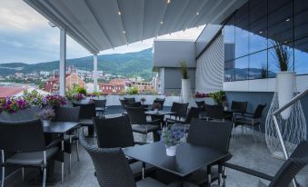 a rooftop dining area with several tables and chairs , some of which are covered in black plastic at Queen's Hotel - Zebra Centre